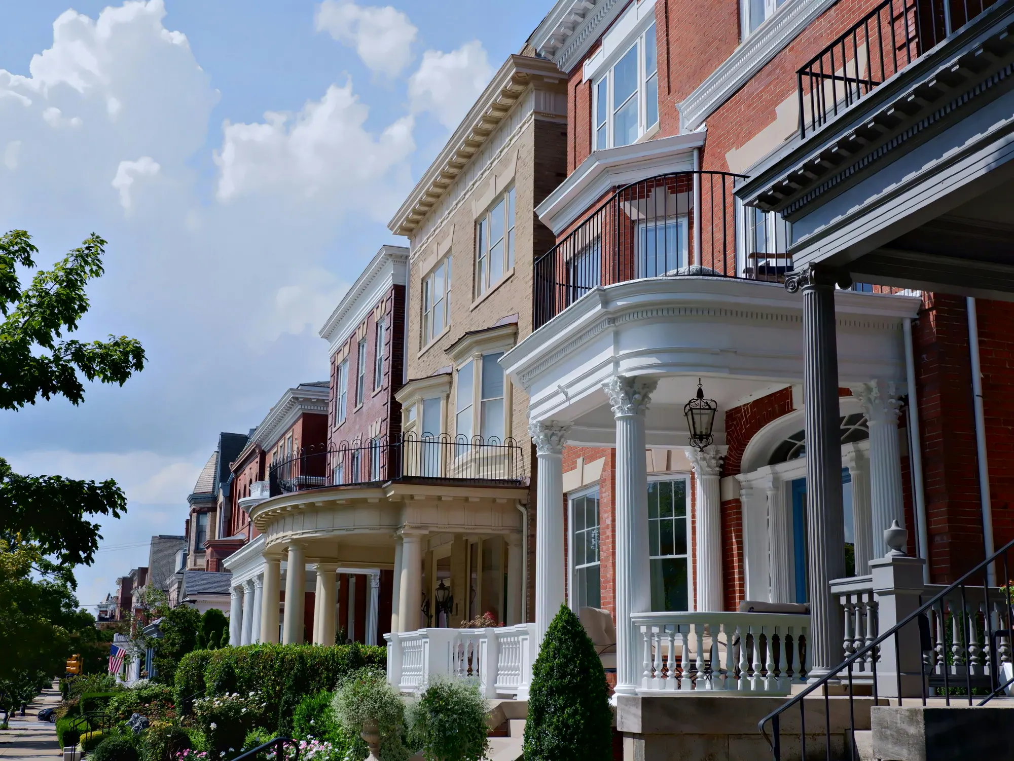 A row of classic brick rowhouses with columned porches in Richmond, Virginia